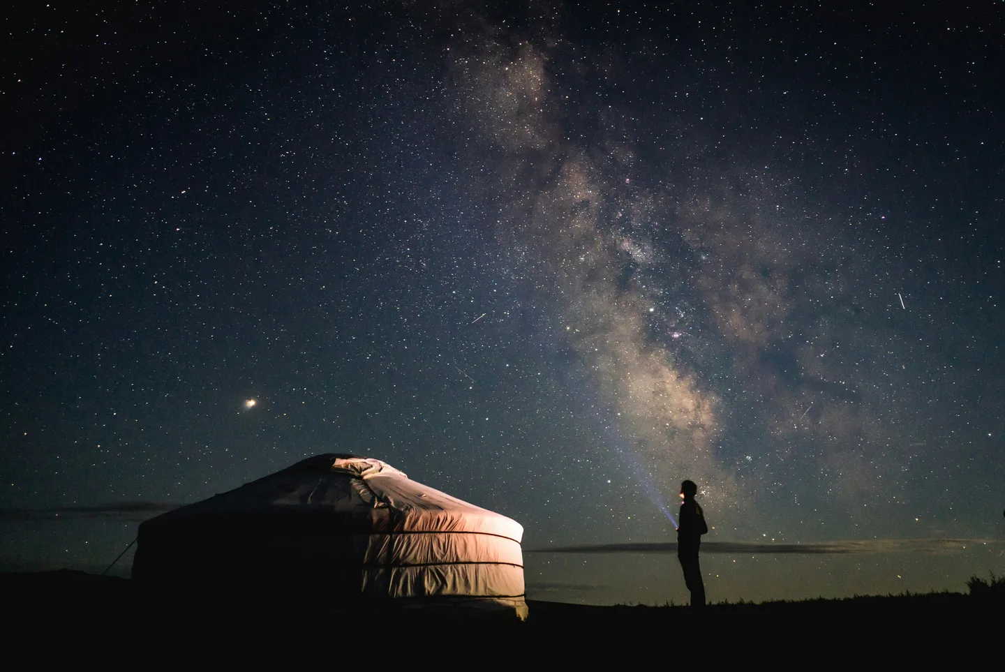 モンゴルの草原に建つゲルと満天の星空